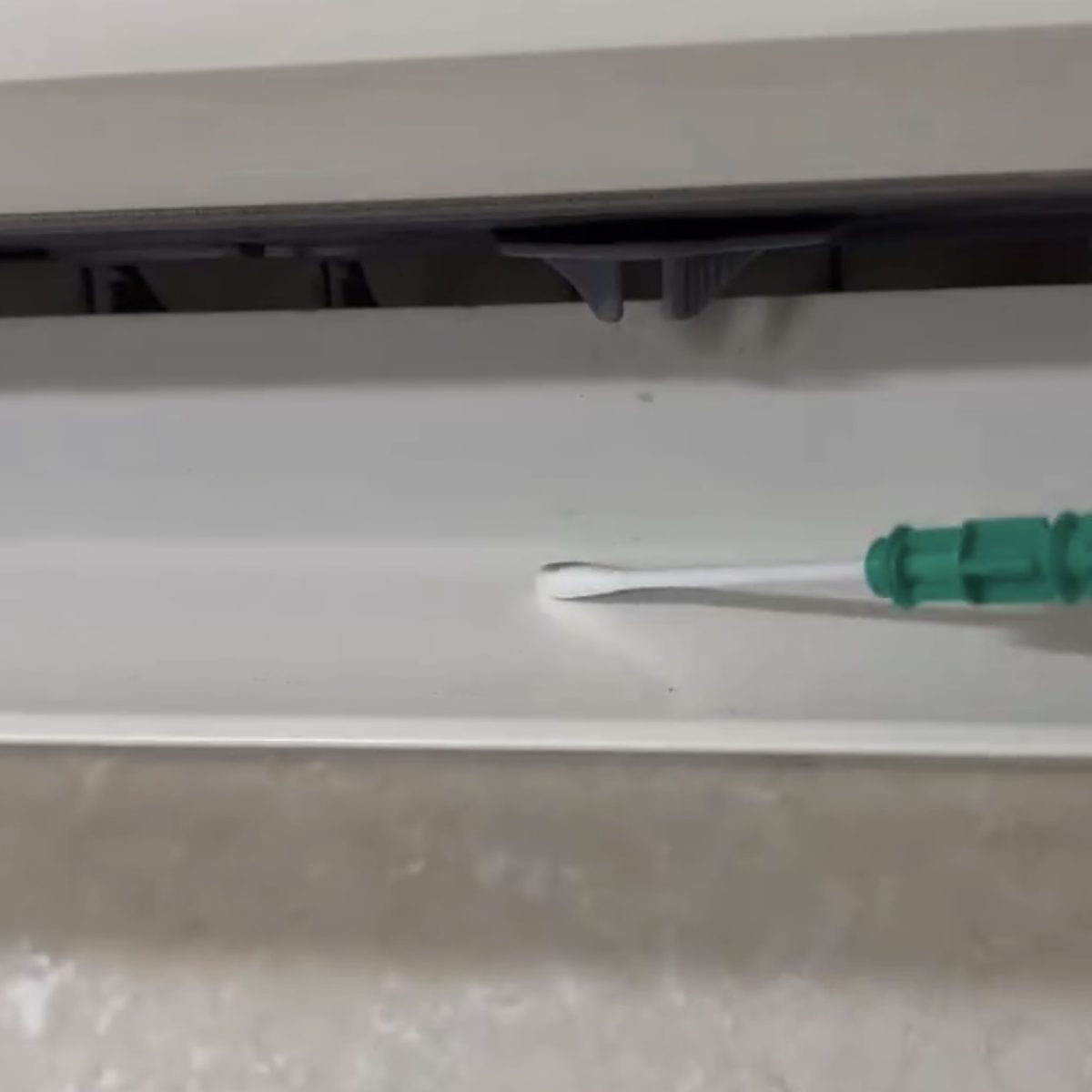 エアコンの吹き出し口を専用綿棒でふき取り、ATP検査を行っている様子