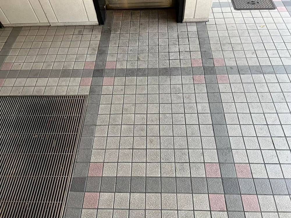 ビルのエントランスのタイル床（定期清掃前）