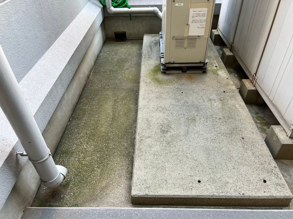 建物まわりのコンクリート（清掃前・コケと黒ずみ）